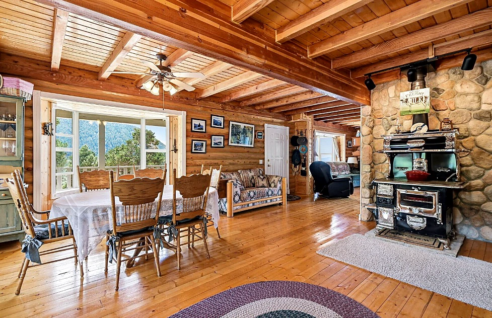 Warm cabin interior with wood beams and stone hearth
