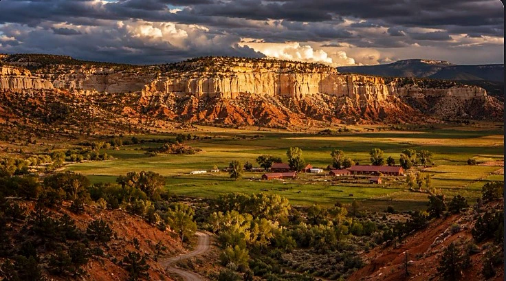 Red and white cliffs above a green ranch valley in Southern Utah
